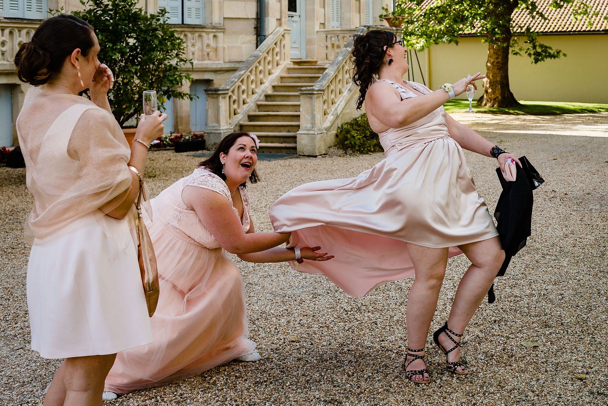 T&eacute;moin de la mari&eacute;e qui s'amuse &agrave; faire de l'air sous la robe captur&eacute; par S&eacute;bastien CLAVEL photographe de Mariage &agrave; Lyon et Gen&egrave;ve