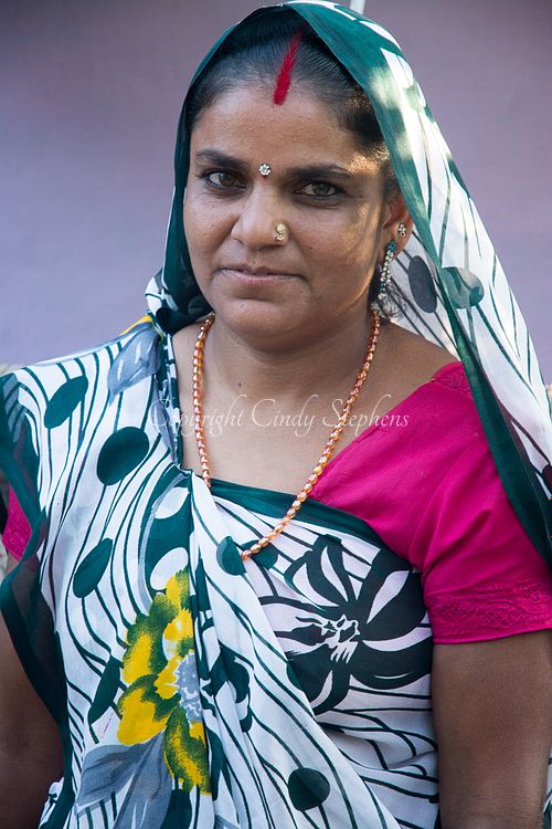 Sita Bhai Phoolchand Khushwaha, wearing a traditional sari and headdress, stands gracefully in Village Rancha, India, showcasing her cultural heritage.