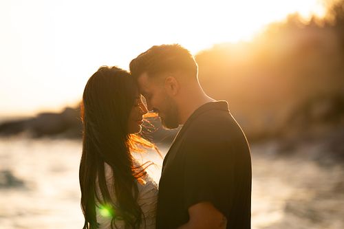 coppia innamorata si guarda in spiaggia al tramonto