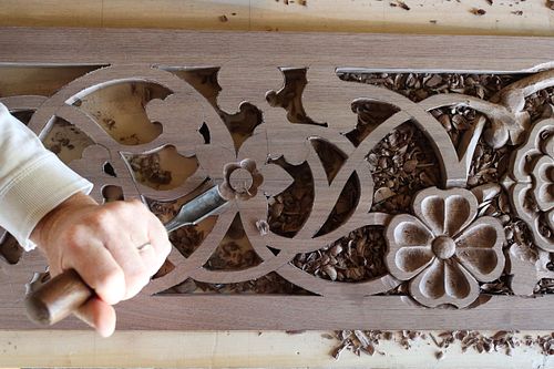 the Begonia flower being carved by hand in the walnut door panel