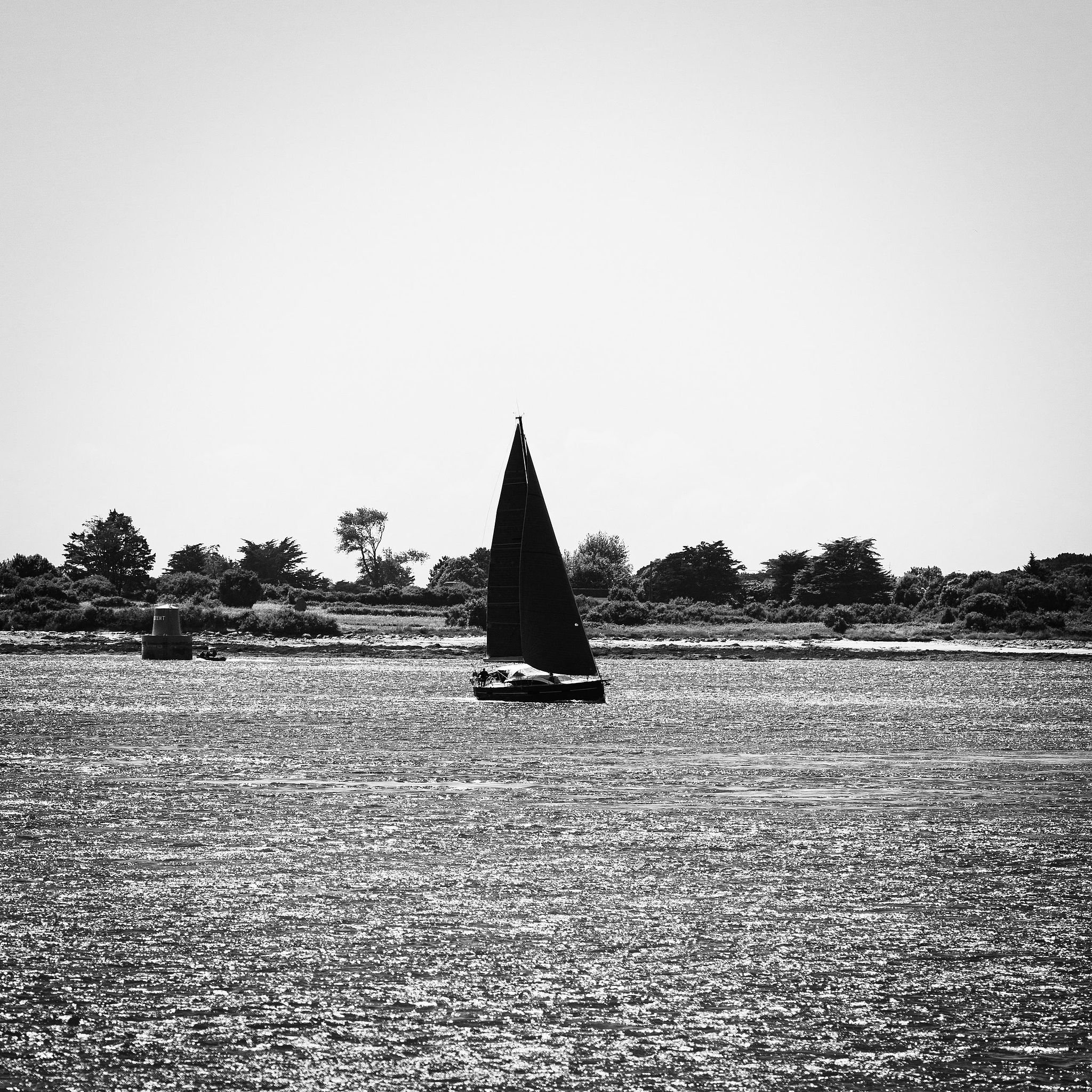 Bateau noir sous ciel contrasté.