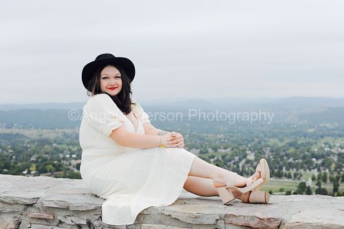 A young women poses on a wall above Rapid City