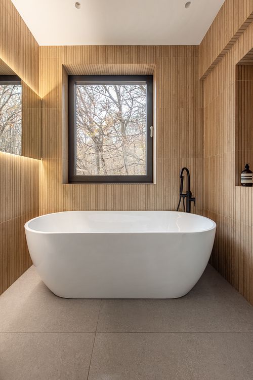 Bathroom interior with forest view, featuring natural textures and soft ambient light – Faget project