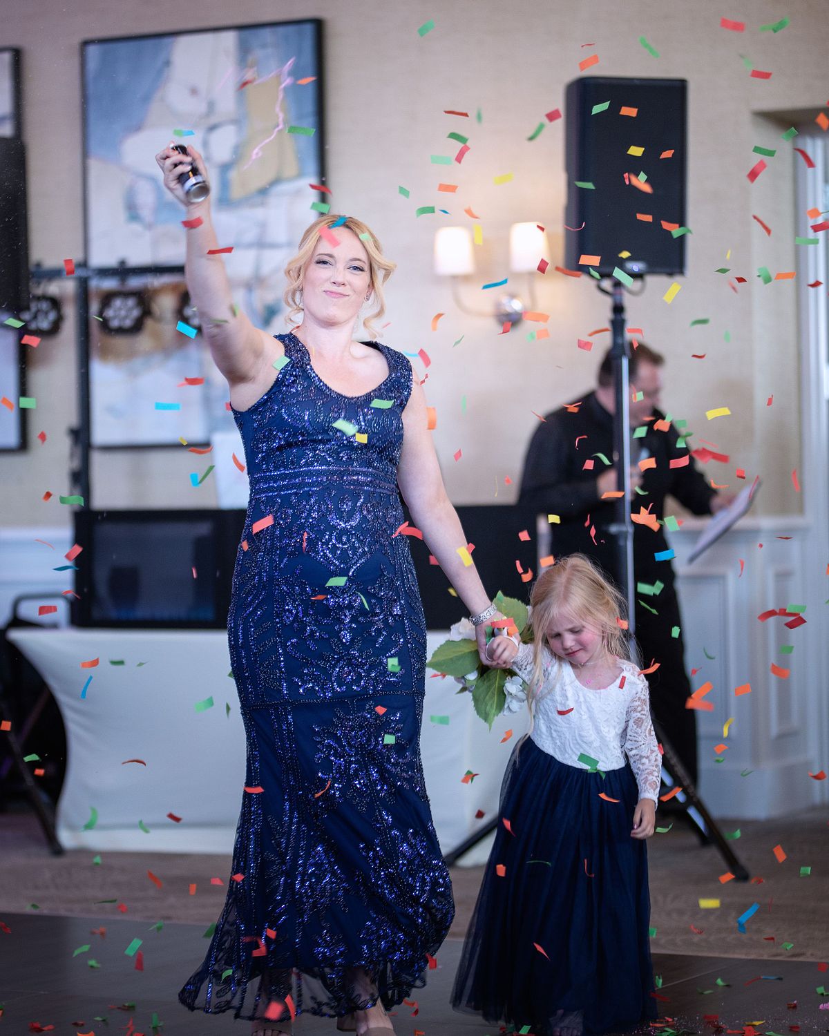 introduction of the maid of honor in the ballroom, the maid of honor is waving her flowers and confetti is falling all around her.