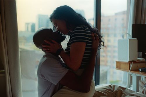 intimate couple sharing a kiss in their bedroom on 35mm film