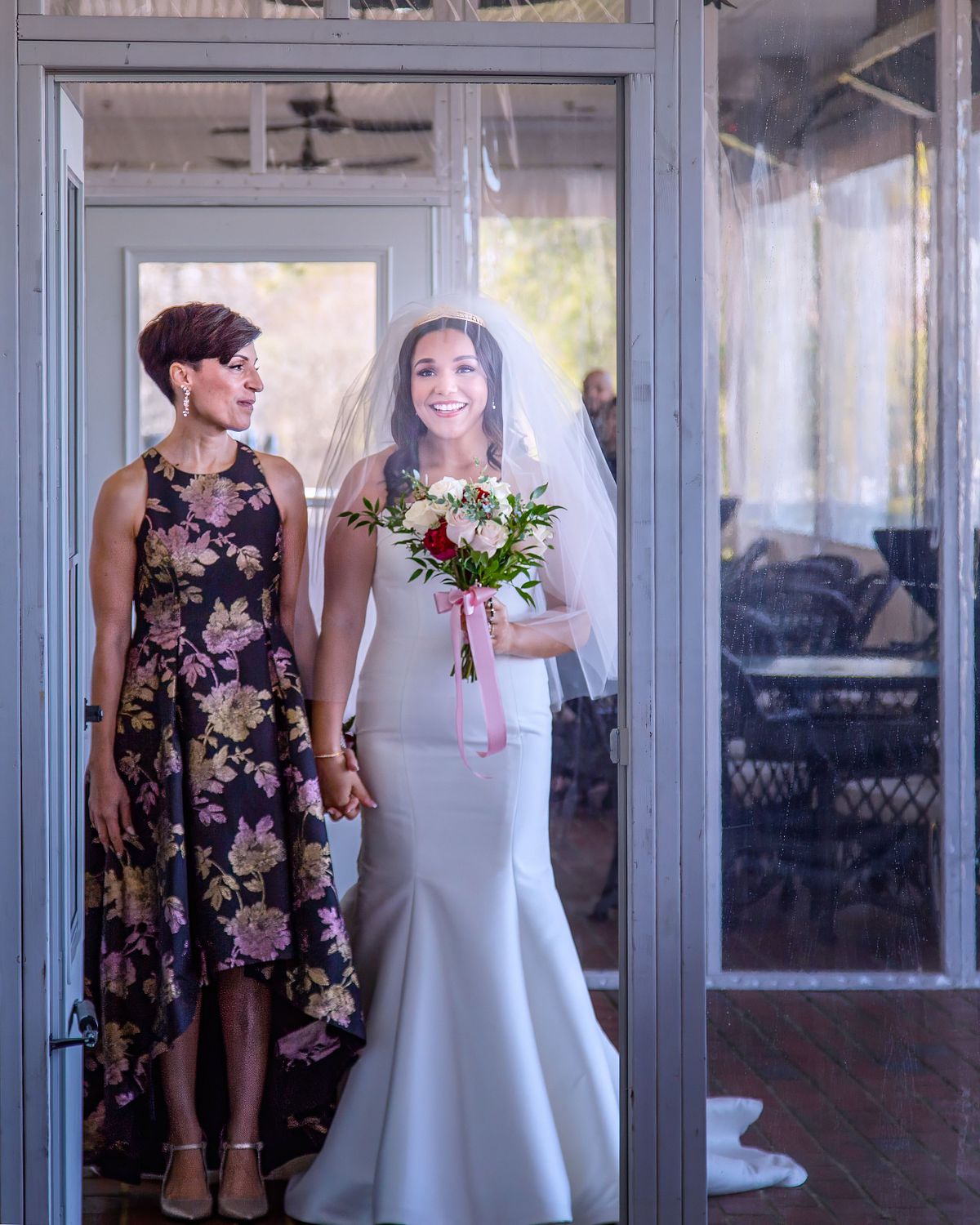 bride and her mother entering the covered porch before the ceremony and stopping in the doorway to take a moment