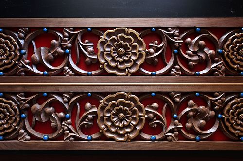 hand-carved rose and vine panel with liturgical red background