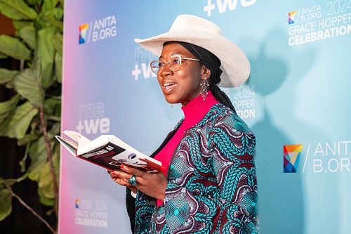 Dr. Joy Buolamwini reads from Unmasking AI during a featured session at the Grace Hopper Celebration 2024.