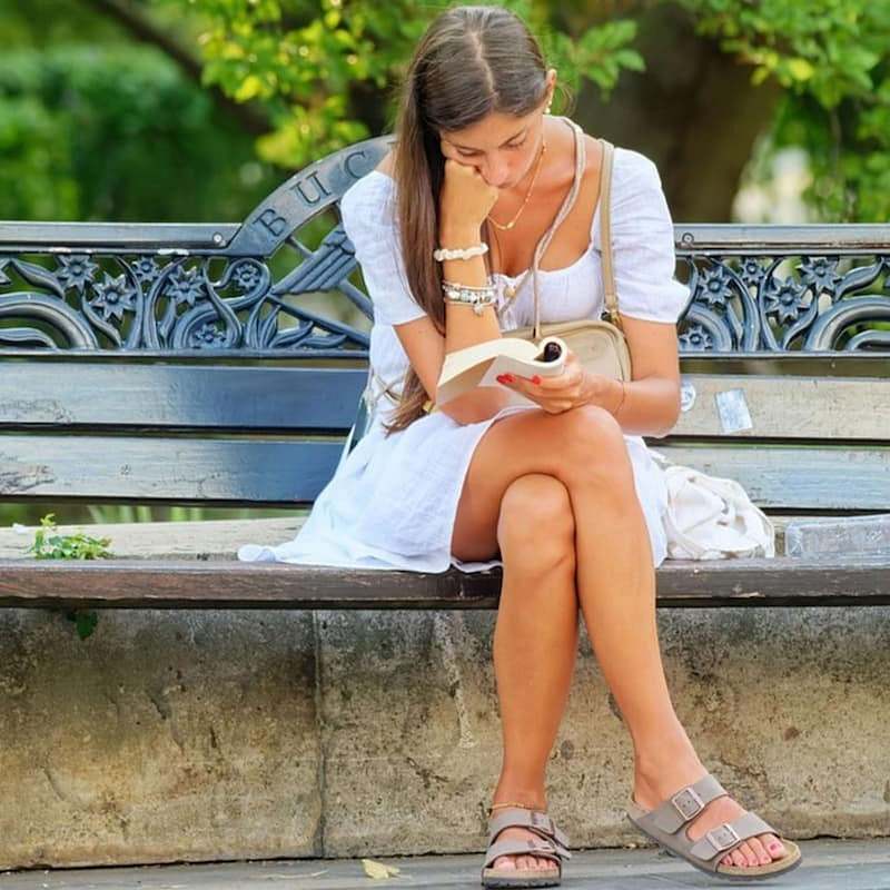 woman on park bench reading