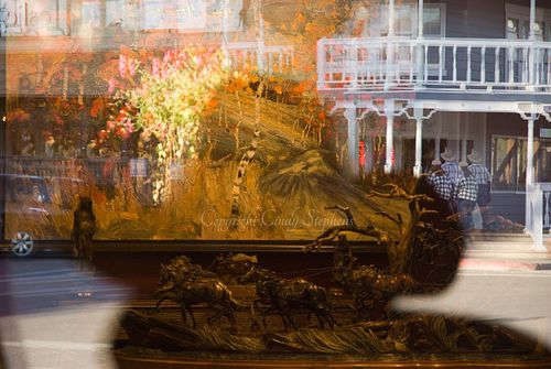Cowboy hat reflection in foreground with a vibrant Jackson Hole Main Street scene in the background, capturing the essence of Western identity.