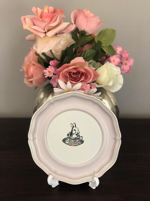 Decorative plate with a flower design, featuring a cute bunny illustration, surrounded by pink roses.