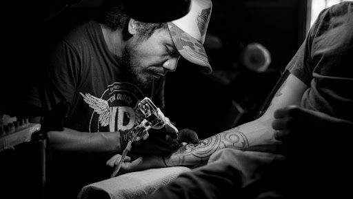 Inchiostrazione del tatuatore sul braccio destro
