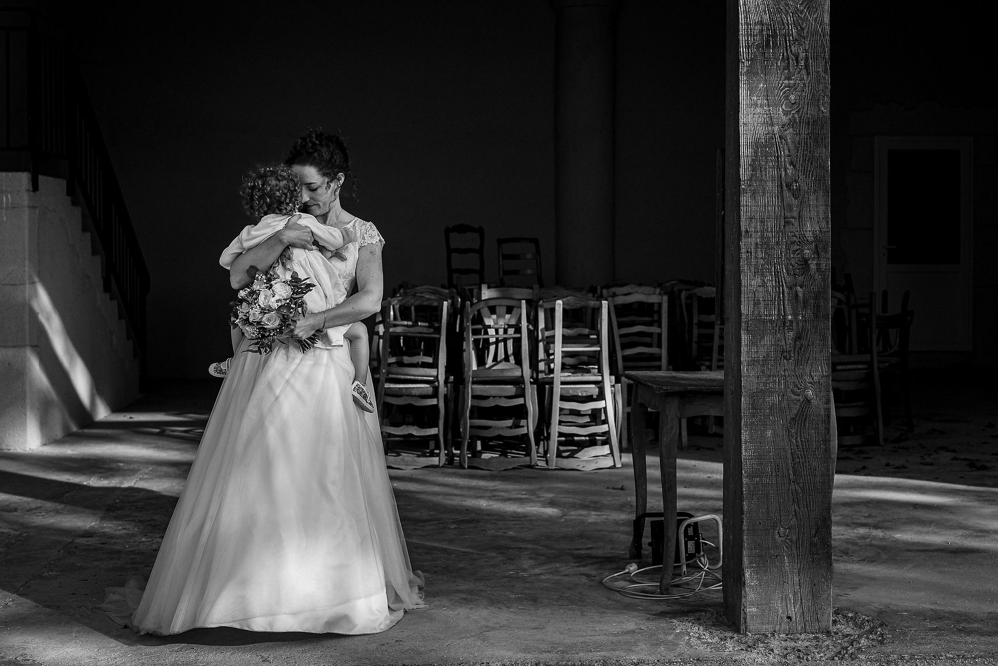 Mari&eacute;e qui tient tendrement sa fille dans les bras captur&eacute; par S&eacute;bastien CLAVEL photographe de Mariage &agrave; Lyon et Gen&egrave;ve