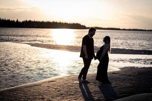 Silhouette of expecting couple at the beach during sunset.