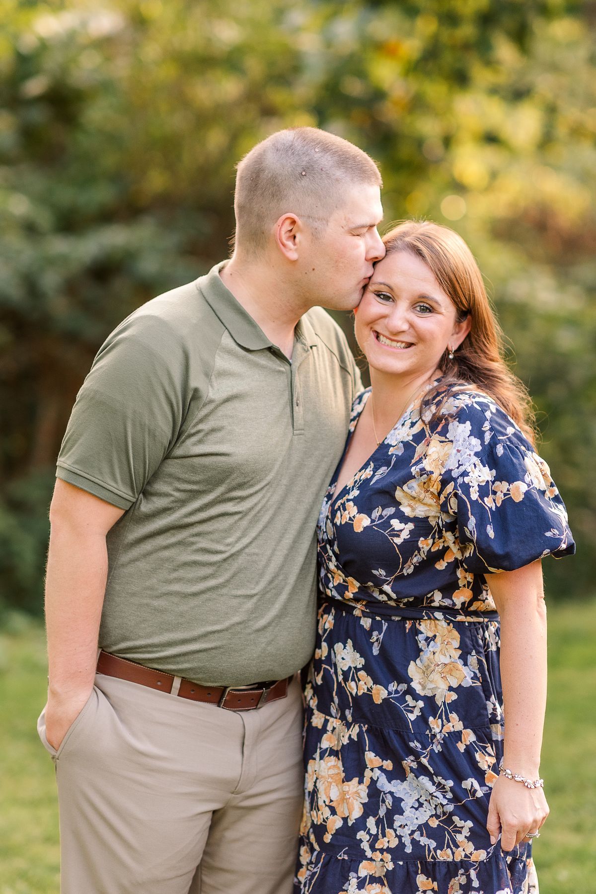 Husband kissing his wife on the forehead while she smiles