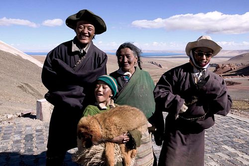 Tibetan people on the high plateau after crossing Nagên La Pass, Tibet, 2007, where human life and landscape merge under drifting clouds.