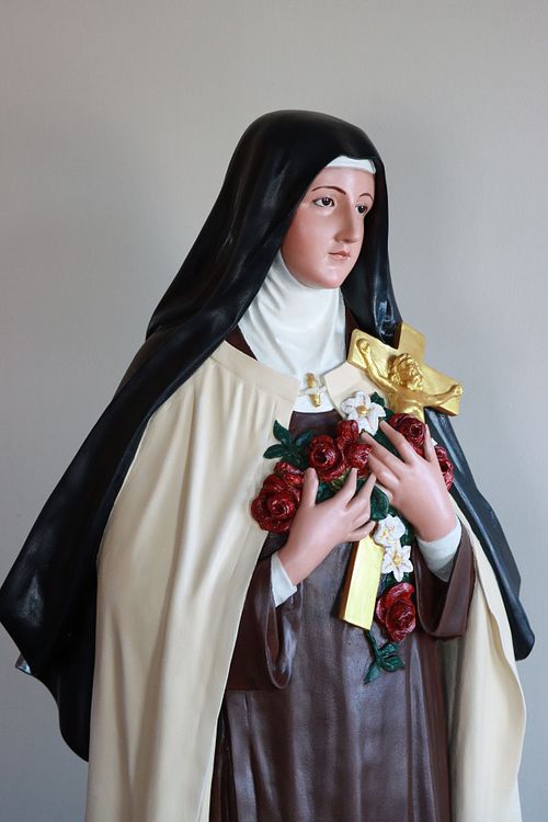 Restored St Therese statue showing the crucifix and flowers