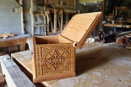 carved oak box with lid open showing how the wooden pintle hinges work