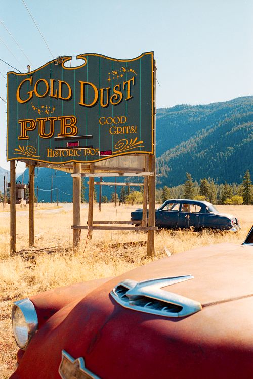 nostalgic film photo of old cars and pub sign