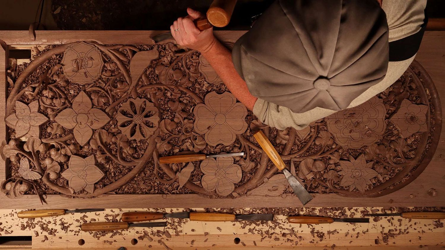 Wes Baker carving the cove on a door panel covered in carved vines, flowers, and birds for a large Shrine for a Crucifix at St. Bernadette Catholic Church in Lancaster, Ohio