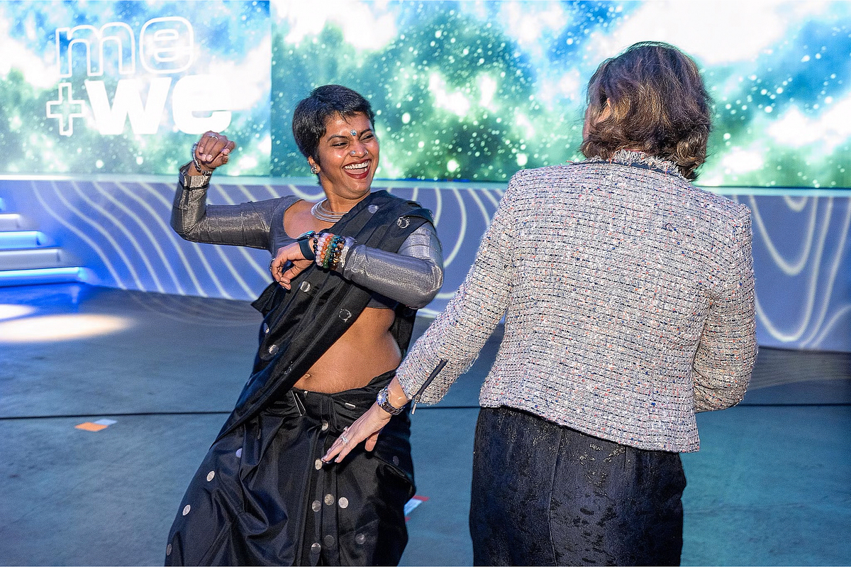 Corporate event photography capturing an AnitaB.org community leader joyfully dancing on stage during the Grace Hopper Celebration 2024 in Philadelphia, highlighting celebration, inclusion, and shared connection within the tech community.