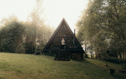 Black A-frame cabin exterior in peaceful Latvian nature
