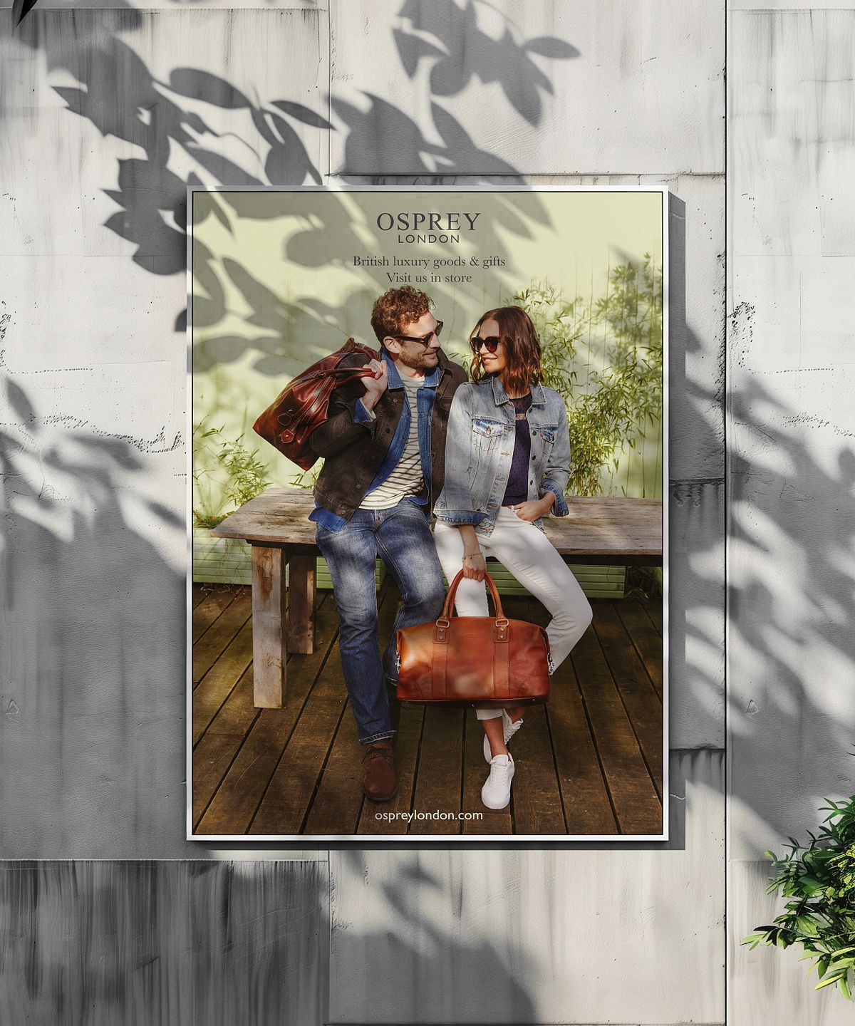 Poster of a couple with leather handbags on a concrete wall with dappled shade