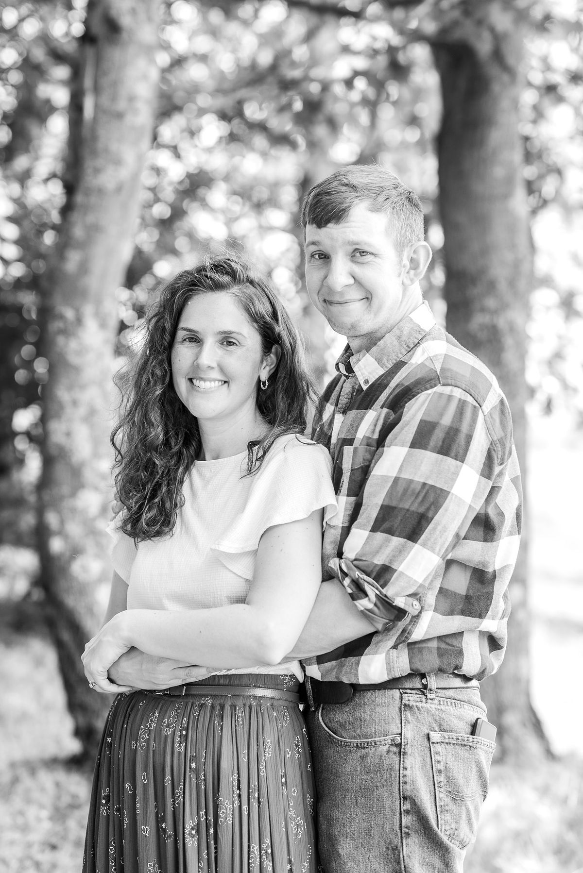 b&w of smiling couple near tall trees with cranberry township, pa newborn photographer