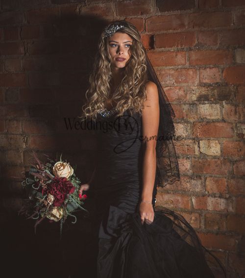 Model wearing a black wedding dress from Bridal Re-Loved Leicester, photographed by Weddings by Jermaine outside the Oadby venue, with hair and makeup by Justaboutweddingshair and beauty, and accessories by Sydney Grace Bridal
