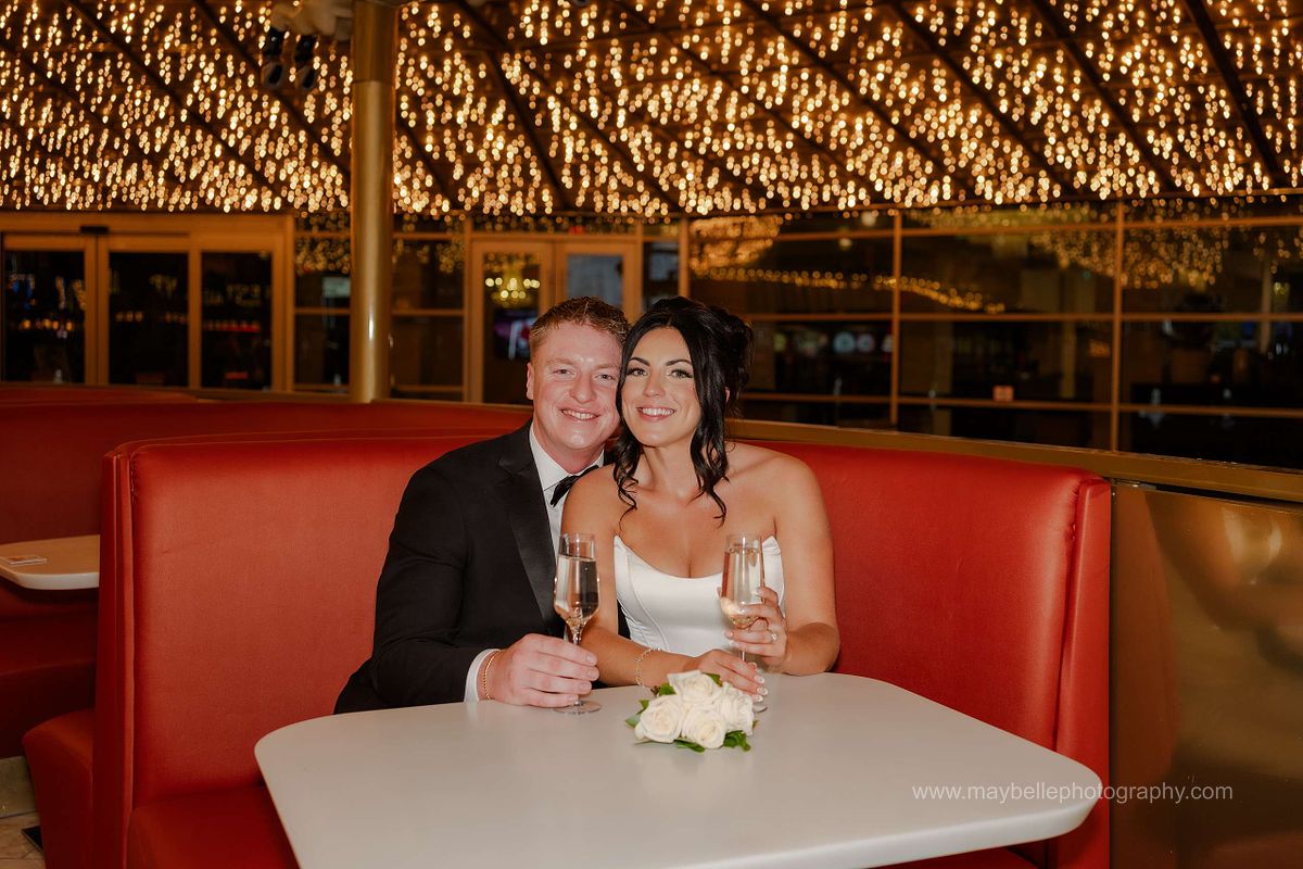 Romantic elopement photos at Carousel Bar in Downtown Las Vegas with couple celebrating with champagne