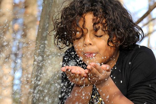 Adorable girls blows on snow
