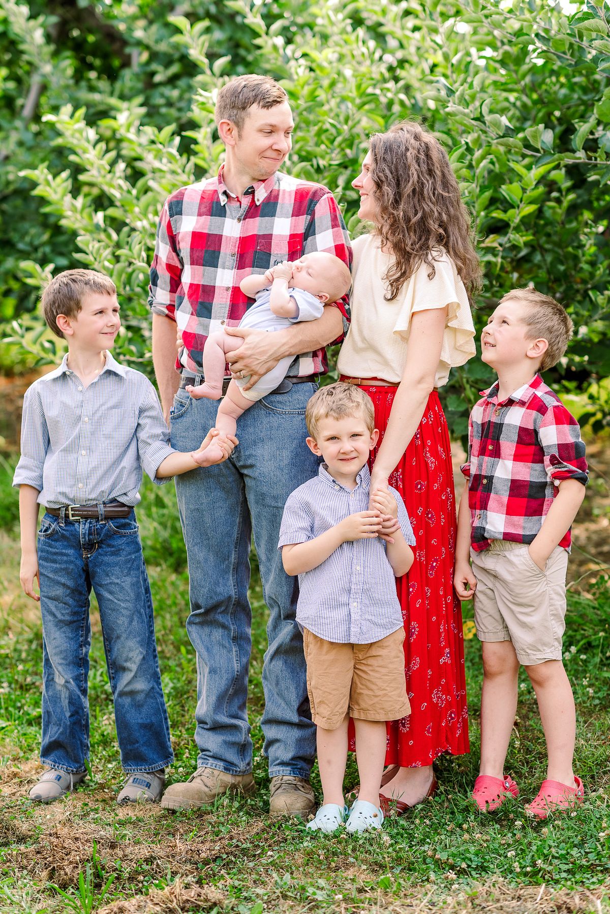 family of six smiling at each other in orchard session with cranberry township, pa newborn photographer