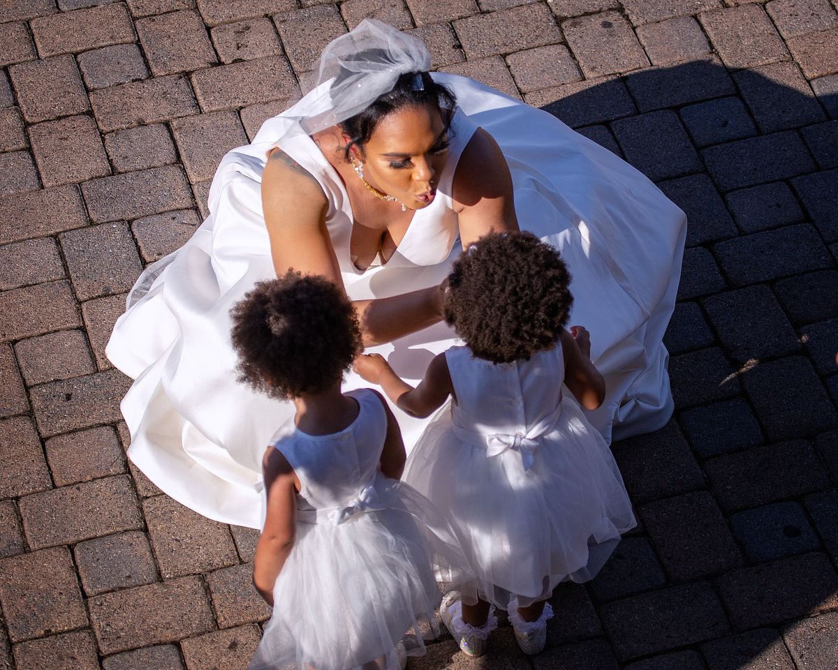 bride kneeling down in front of her twins talking