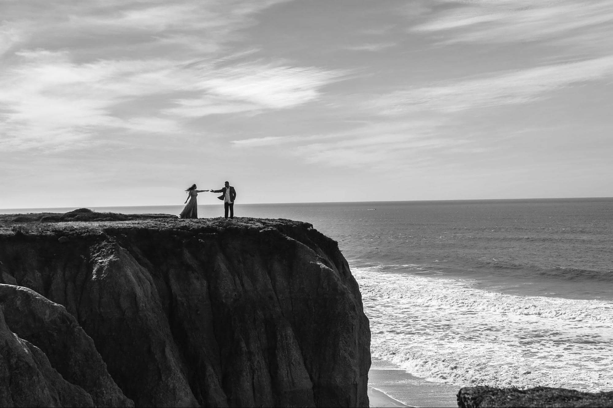 Image de deux modèles posant sur une falaise au bord de la mer