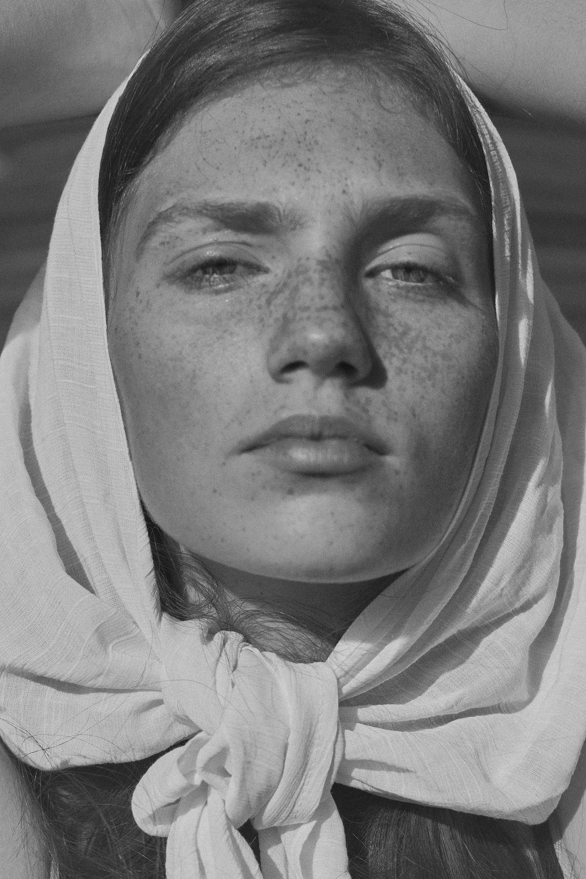 Black and white fine art portrait of a woman with a headscarf, photographed in a timeless cinematic style by Gabriel Matula.