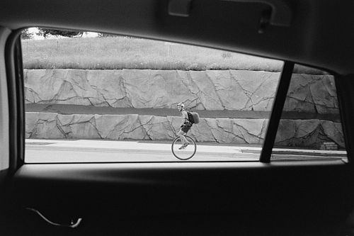 35mm film of unicycle passing by car