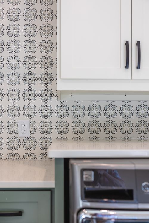 Washer and dryer on pedestals, built-in custom cabinets, fun wall tile