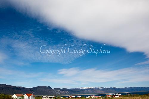 Bright colors with a sweeping blue sky and seaside community