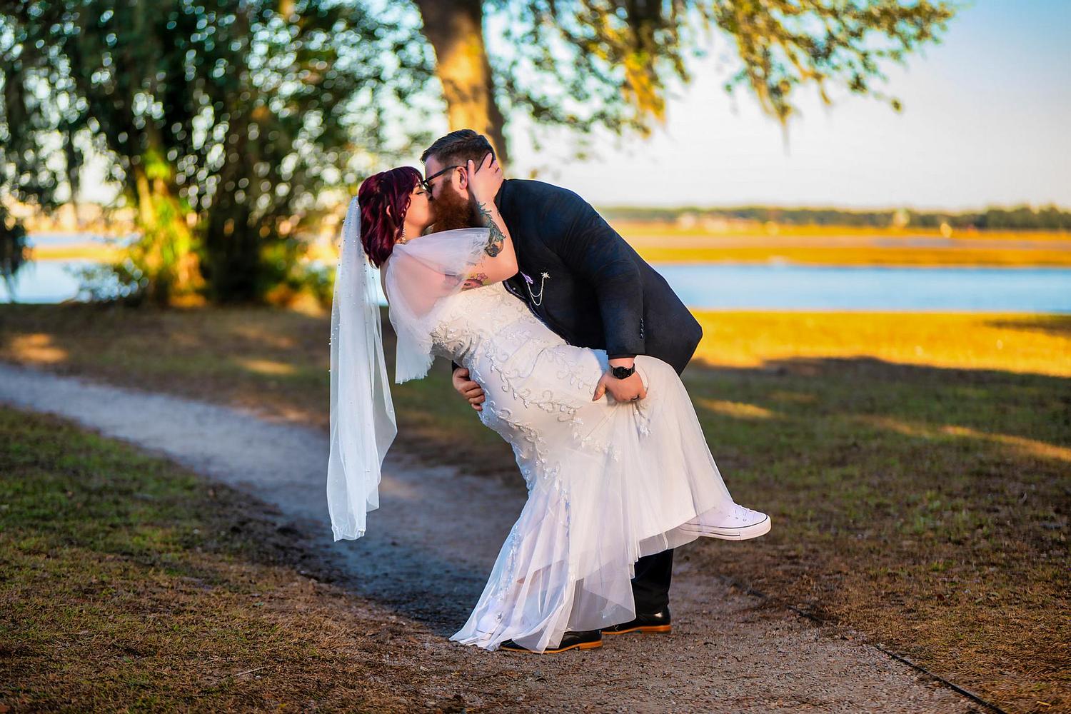 Groom dipping bride for a kiss during their elopement photography session in Beaufort, South Carolina.