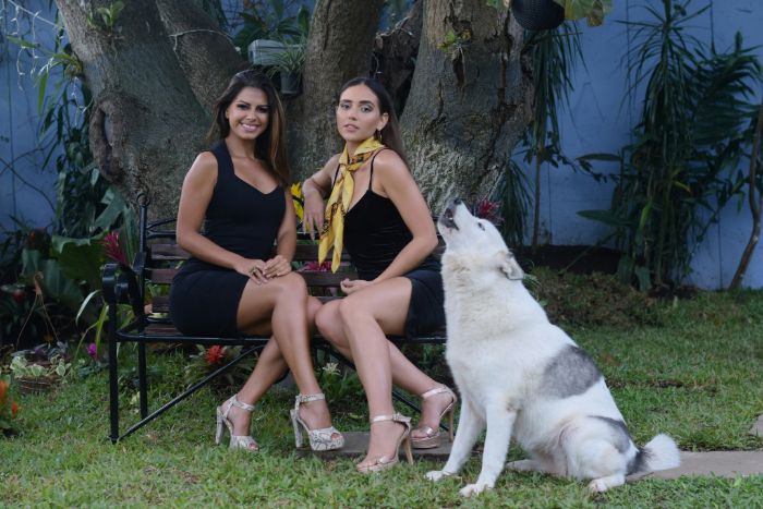 Models sitzen für ein Fotoshooting auf dem Stuhl, neben ihnen ein Hund