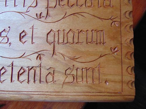 close up of the letter carving on the carved cherry box lid for a priest's ordination