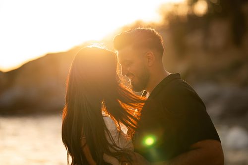 coppia innamorata si guarda in spiaggia al tramonto