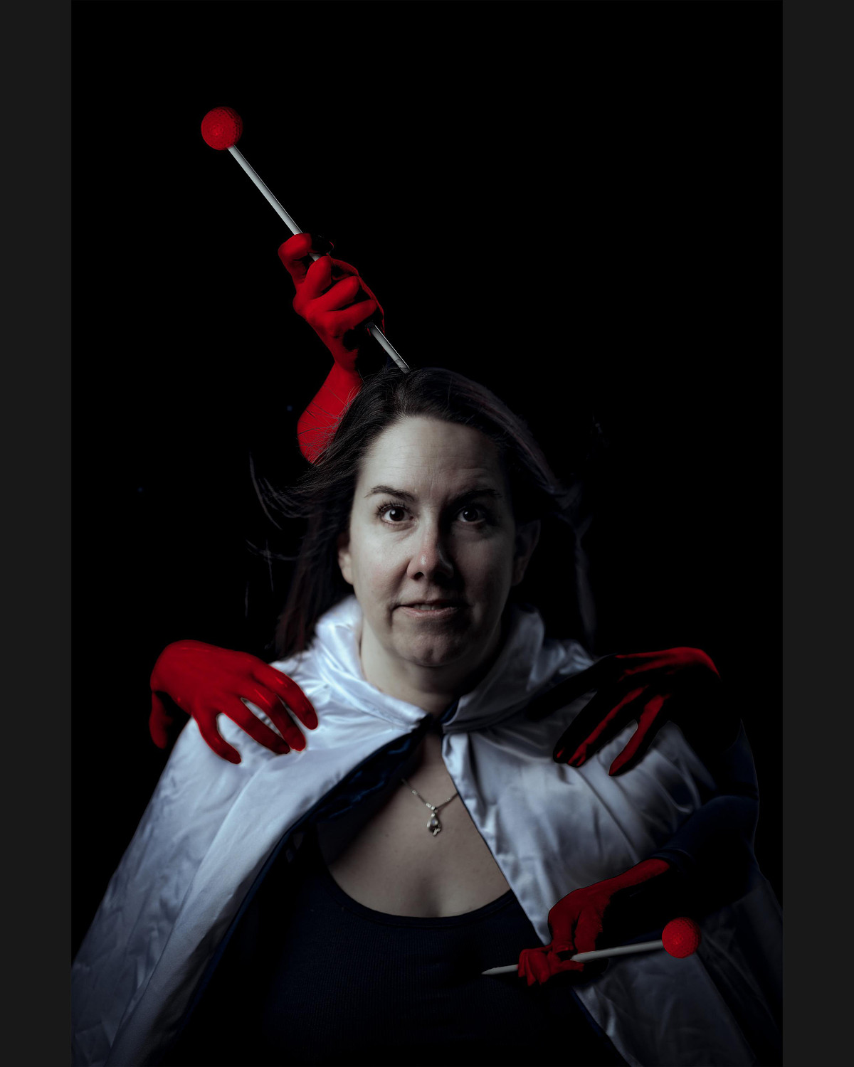 Symbolic self-portrait using red, hands and pins.