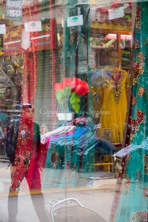 A vibrant shop window display of beautifully colored silk dresses, reflecting the rich culture of Kathmandu.