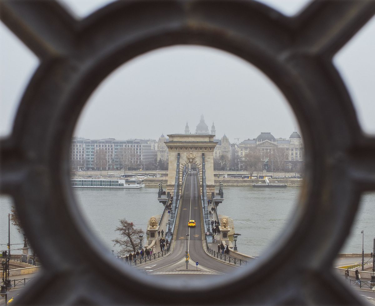 Budapest avvolta dalla nebbia mattutina, con edifici e ponti che emergono tra le nuvole, creando un&rsquo;atmosfera sospesa e misteriosa