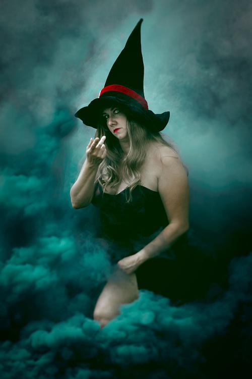 A seductive witch surrounded by smoke.